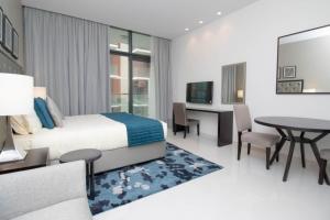 a bedroom with a bed and a desk and a table at Affordable Living near Dubai Al Makhtom Airport - Ezytrac Vacation Homes in Dubai