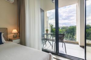 une chambre avec un lit et un balcon avec une table dans l'établissement Marine Deluxe Apartment, à Saints Constantine et Helena 32 autres photos