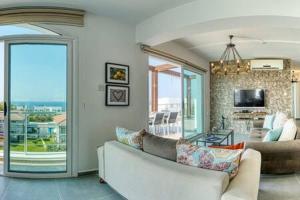 un soggiorno con un divano bianco e una grande finestra di Joya Cyprus Diamond Deluxe Penthouse Apartment a Saint Amvrosios