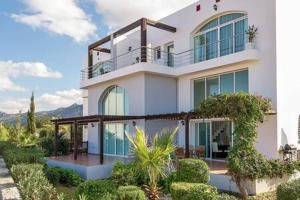 a large white house with a balcony on top of it at Joya Cyprus Maroon Garden Apartment in Saint Amvrosios