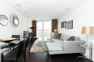 a living room with a couch and a table at Stylish Central 2BR Flat, Belgravia, Chelsea in London