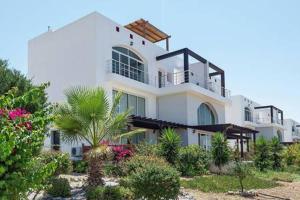a large white building with a lot of plants at Joya Cyprus Mandalay Penthouse Apartment in Saint Amvrosios