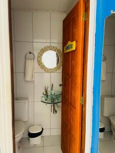 een badkamer met een wastafel, een toilet en een spiegel bij Pousada Vila Milagres in São Miguel dos Milagres