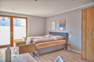 een slaapkamer met een bed, een stoel en een tafel bij City Apparte Exklusiv - direkt am Antonius-Hospital - Auto-E-Ladestation in Gronau