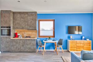 een keuken met blauwe muren en een tafel en stoelen bij City Apparte Exklusiv - direkt am Antonius-Hospital - Auto-E-Ladestation in Gronau