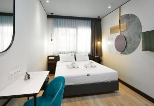 a hotel room with a bed and a desk and chair at Urban Elephant Suites in Thessaloniki