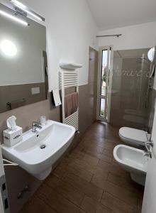 W łazience znajduje się umywalka, toaleta i lustro. w obiekcie Vele Storiche Pisane w Pizie