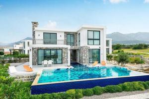 a large house with a swimming pool in front of it at Joya Cypern Seaside Luxurious Villa and Private Pool in Akanthou