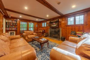 a living room with leather furniture and a fireplace at Cranmore Mountain Lodge Bed & Breakfast in North Conway