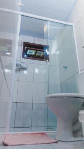 a bathroom with a glass shower and a toilet at Casa Mico Leão Dourado in Bombinhas