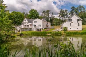 una casa con un estanque delante de ella en Cranmore Mountain Lodge Bed & Breakfast, en North Conway