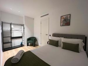 a bedroom with a large bed and a green chair at Stay U-nique Apartment Putxet in Barcelona
