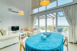 een woonkamer met een tafel met een blauwe tafeldoek bij Joya Cyprus Sea Sunset View Garden Apartment in Arsos