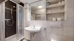 a white bathroom with a sink and a shower at strandnahe FeWo mit Schwimmbad im Haus, a cappella 63, Binz in Binz