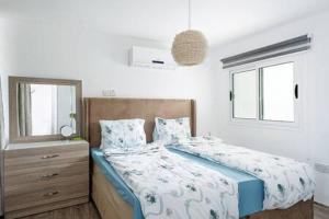 a bedroom with a bed and a dresser and windows at Joya Cyprus Stargazer Garden Apartment in Saint Amvrosios +24 photos