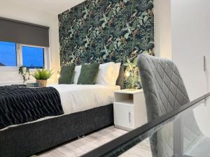 - une chambre avec un grand lit et une chaise dans l'établissement City Centre Apartments for Large Groups - Superb Location & Next to Tube Station, à Ealing