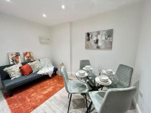 - un salon avec une table, des chaises et un canapé dans l'établissement City Centre Apartments for Large Groups - Superb Location & Next to Tube Station, à Ealing