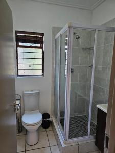 a bathroom with a toilet and a shower at Premium Apartment In Fourways in Sandton
