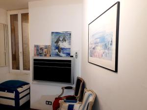 sala de estar con TV de pantalla plana en la pared en Downtown, en Niza