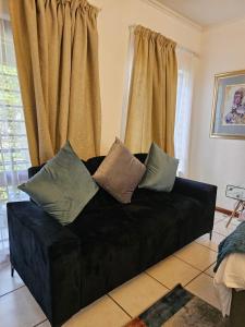 a black couch with pillows on it in a living room at Premium Apartment In Fourways in Sandton