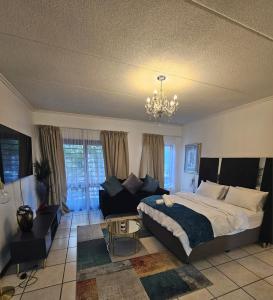 a bedroom with a large bed and a couch at Premium Apartment In Fourways in Sandton