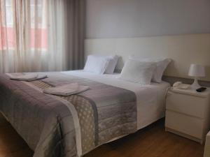 リスボンにあるレジデンシャル ヴァレンティナのベッドルーム1室(大型ベッド1台、白いシーツ、枕付)