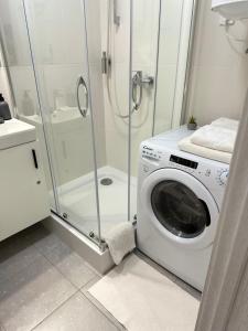 een wasmachine in een badkamer met een douche bij CUBE House in Kiev