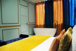 Schlafzimmer mit einem Bett und einer Badewanne in der Unterkunft ROYAL SUITE PARIS REPUBLIQUE in Paris