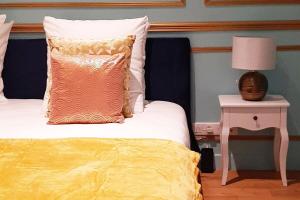 ein Bett mit einer gelben Decke und einer Lampe auf dem Tisch in der Unterkunft ROYAL SUITE PARIS REPUBLIQUE in Paris