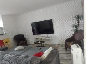 uma sala de estar com uma televisão de ecrã plano na parede em Cobertura na praia da Ribeira, temporada de carnaval de 09 a 14/02 em Angra dos Reis