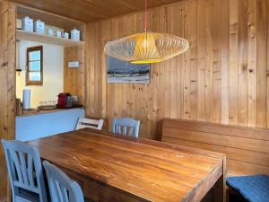 comedor con mesa de madera y lámpara de araña en Chalet Marolly - Evolène, en Evolène