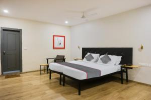 a bedroom with a large bed and a black door at Townhouse 1118 The B&W Motel in Visakhapatnam