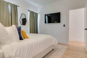 a bedroom with a bed with a television on the wall at The Alessia - Downtown Luxury in Gated Community in Nashville