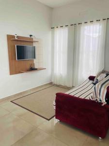 a living room with a couch and a tv in a room at Casa com Piscina e ótimo custo benefício!! in Brotas