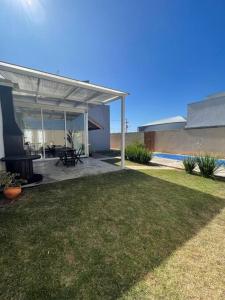 a house with a patio with a grill and a yard at Casa com Piscina e ótimo custo benefício!! in Brotas