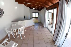 cocina y comedor con mesa y sillas en Cobertura duplex com linda vista para o mar de Bombas, en Bombinhas