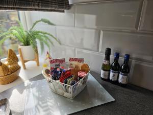 una cesta de galletas y botellas de vino en un mostrador en Hop Cottage en Mirfield