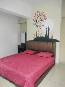 a bedroom with a pink bed with a tree on the wall at “彬彬”星空瞭望台 ( The Venus 33rd floor @ Sri Manjung ) in Kampong Lumut Kiri