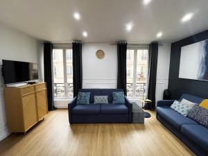 a living room with two blue couches and a flat screen tv at 17 - Pretty Flat in Paris Montorgueil 2 in Paris