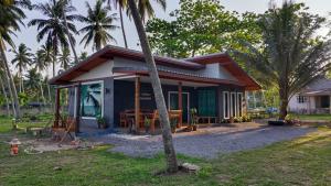 ein kleines Haus mit einer Palme davor in der Unterkunft บ้านระเบียงเลหลังสวน 1 ห้องริมทะเล in Ban Hin Sam Kon