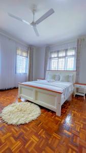 a bedroom with a large white bed with a rug at Villa Ella in Mombasa