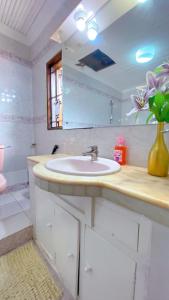 a bathroom with a sink and a vase of flowers at Villa Ella in Mombasa