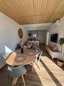 Apartamento Ronda III في فوينخيرولا: غرفة معيشة بسقف خشبي وطاولة وكراسي