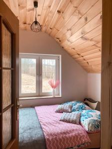 a bedroom with a bed and a window at DOLINA ROZTOKI-mieszkanie,pokoje lub domek z lokalem na poddaszu in Bircza