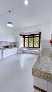 a large kitchen with white cabinets and a large window at Villa Ella in Mombasa