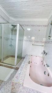 蒙巴薩的住宿－Villa Ella，带浴缸和玻璃淋浴间的浴室。