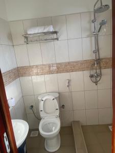 a bathroom with a toilet and a sink at 7 Days Hotel in Entebbe