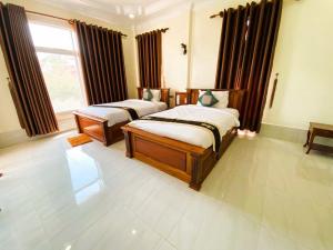 two beds sitting in a room with a window at Asia Ready Travel & Tours Siem Reap in Siem Reap