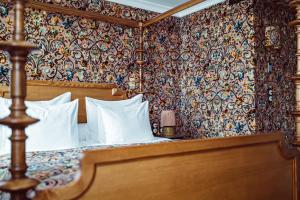 um quarto com uma cama com almofadas brancas em Hôtel Eldorado Paris em Paris