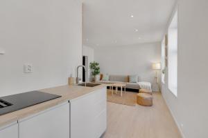 a kitchen with white cabinets and a living room at Fantastic apartment in Oslo in Oslo
